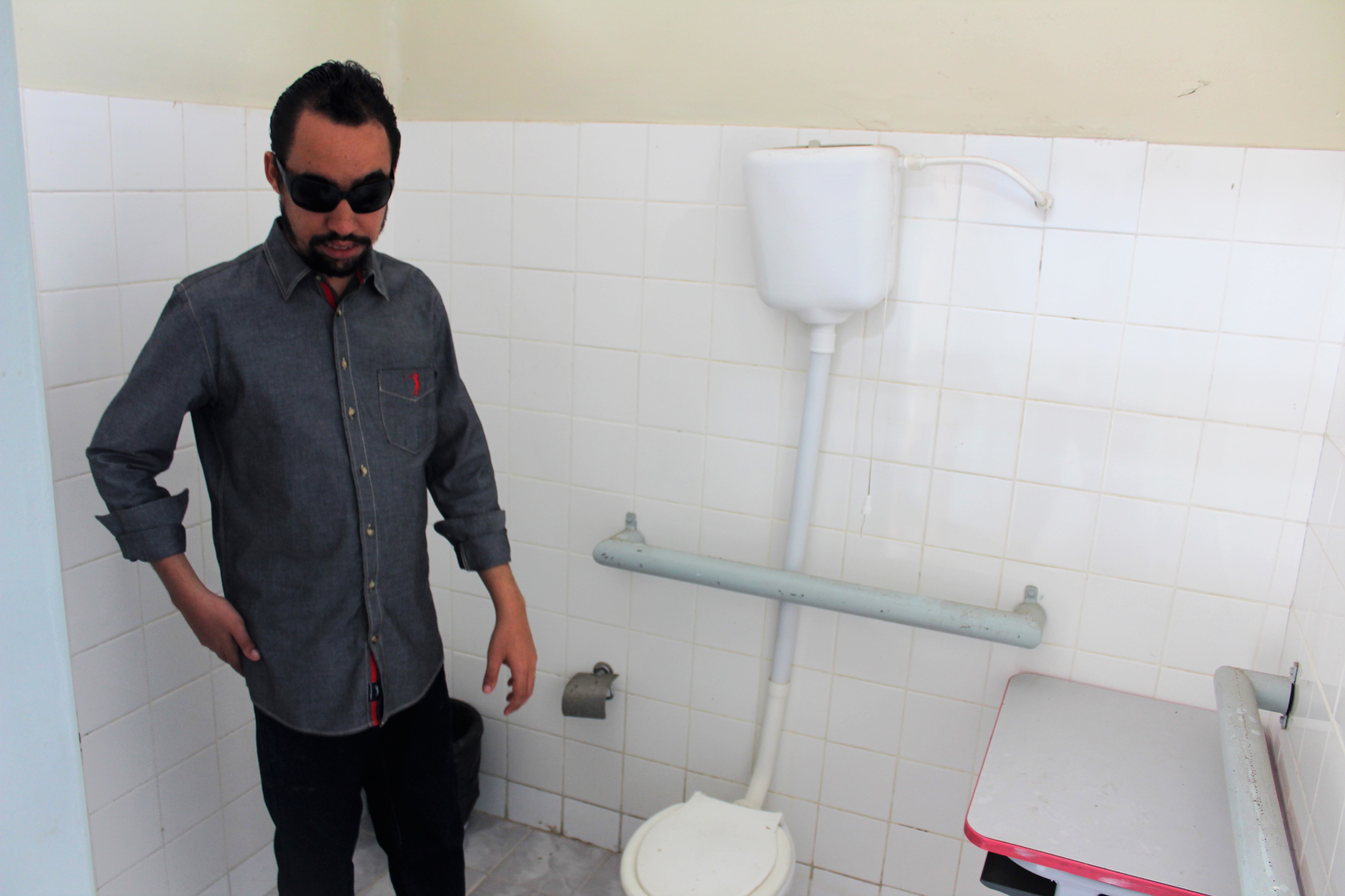 #PraCegoVer: Lucas verifica situação do banheiro adaptado