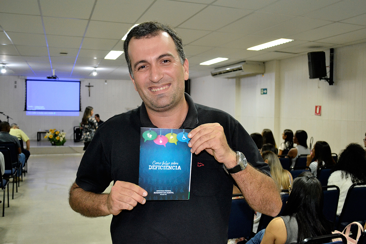#PraCegoVer - Rozendo Aragão, jornalista e radialista, exibe guia para comunicadores distribuído no evento