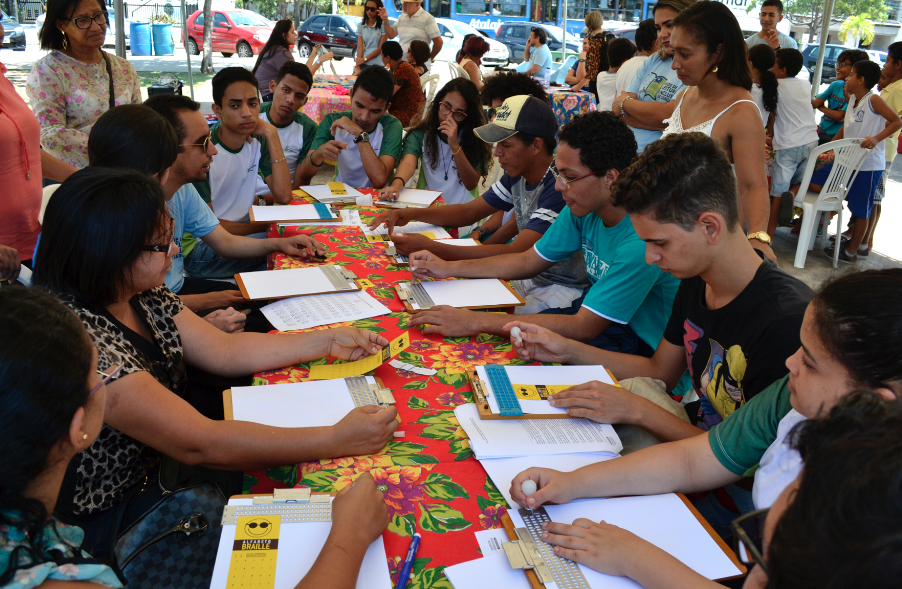 #PraCegoVer - Pessoas participam de oficina de braile ministrada por Lucas Aribé