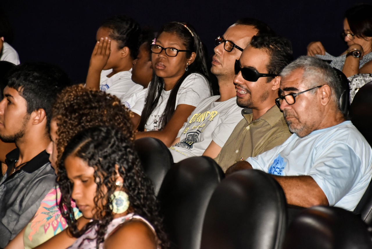 #PraCegoVer: O vereador Lucas Aribé e outras pessoas estão sentadas atentas ao filme