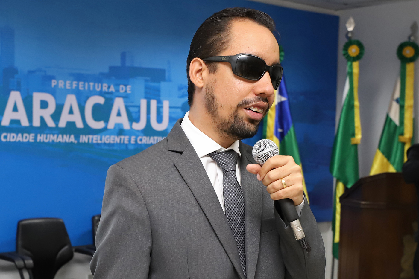 #PraTodoMundoVer Lucas Aribé falando ao microfone no auditório da Prefeitura (Foto: Marcelle Cristinne)