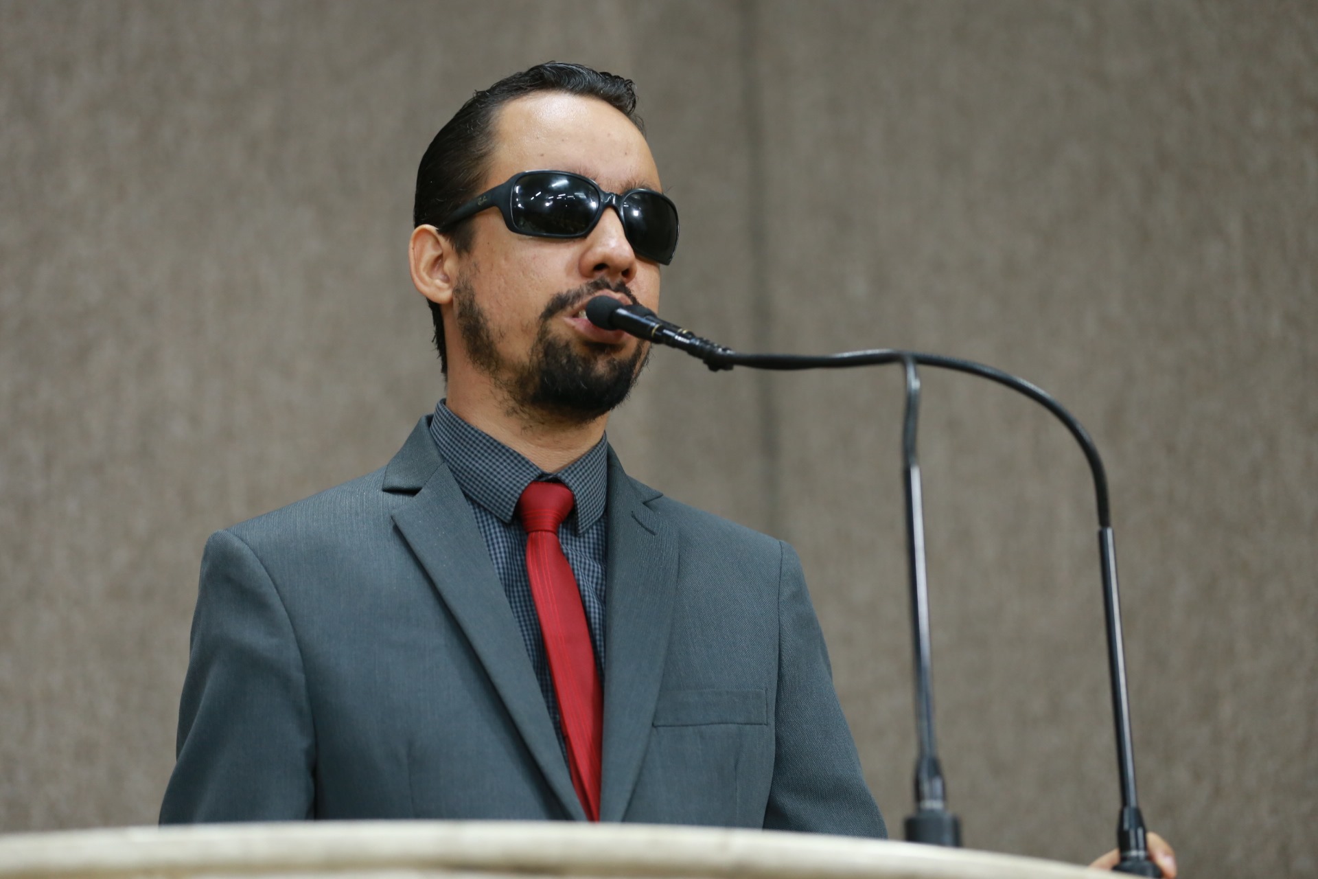 #PraTodoMundoVer Lucas em pé falando na tribuna da Câmara. Ele usa terno e camisa cinzas e gravata vermelha. (Foto: Gilton Rosas)